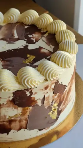 Buttercream cake with chocolate-toned painted finish and piped border
